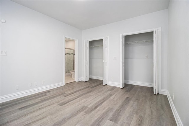 5690 Rutland Trce, Lithonia, GA 30058 - unfurnished bedroom with two closets, wood finished floors, and ensuite bathroom