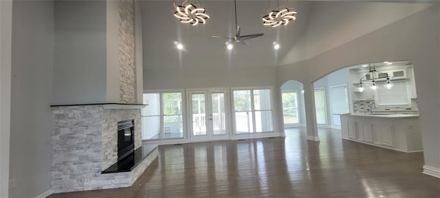 5690 Rutland Trce, Lithonia, GA 30058 - unfurnished living room with a chandelier, a fireplace, high vaulted ceiling, arched walkways, and ceiling fan