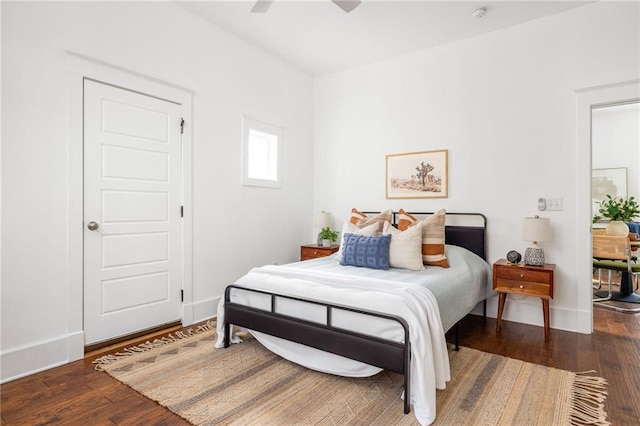 bedroom featuring hardwood / wood-style flooring, a ceiling fan, and baseboards