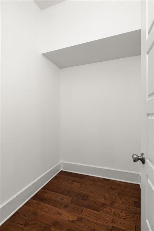 empty room with baseboards and dark wood-style floors