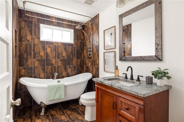 full bath featuring visible vents, wood tiled floor, toilet, a freestanding tub, and vanity