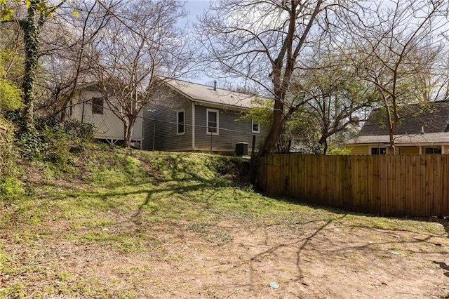 view of yard with central AC unit and fence