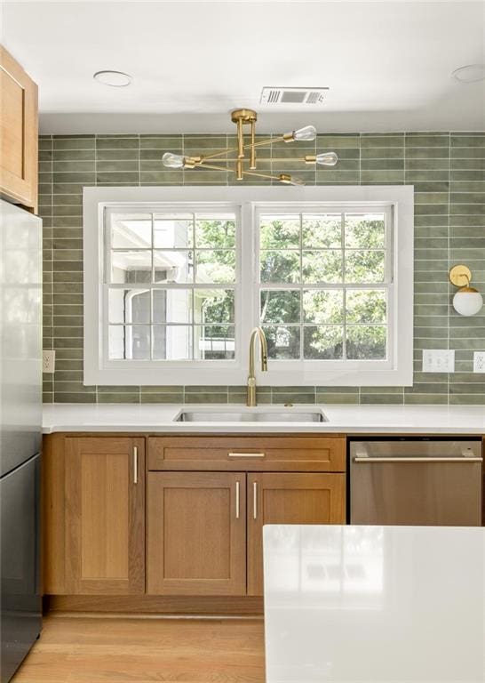 762 Rockbridge Rd NW, Lilburn, GA 30047 - kitchen featuring stainless steel appliances, a sink, backsplash, light countertops, and light wood-type flooring