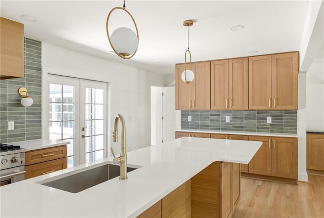 762 Rockbridge Rd NW, Lilburn, GA 30047 - kitchen with a sink, light countertops, decorative backsplash, and hanging light fixtures