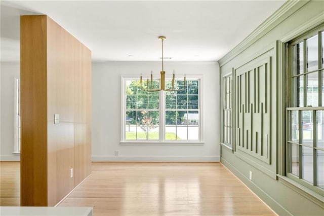 762 Rockbridge Rd NW, Lilburn, GA 30047 - unfurnished dining area featuring light wood-style flooring, baseboards, a chandelier, and ornamental molding