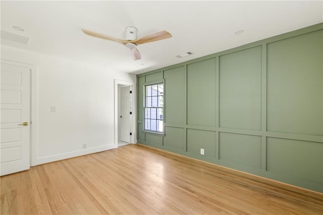762 Rockbridge Rd NW, Lilburn, GA 30047 - spare room featuring a decorative wall, light wood finished floors, a ceiling fan, and baseboards
