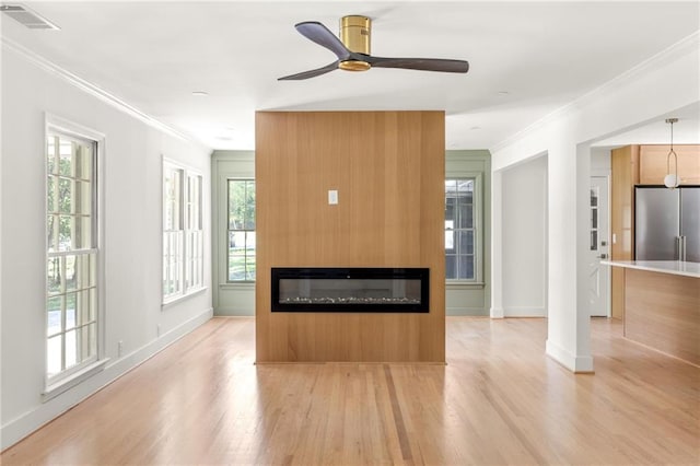 762 Rockbridge Rd NW, Lilburn, GA 30047 - unfurnished living room with crown molding, light wood-type flooring, a glass covered fireplace, ceiling fan, and baseboards