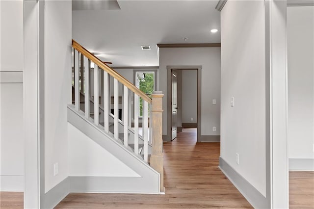 foyer entrance with ornamental molding and light hardwood / wood-style floors