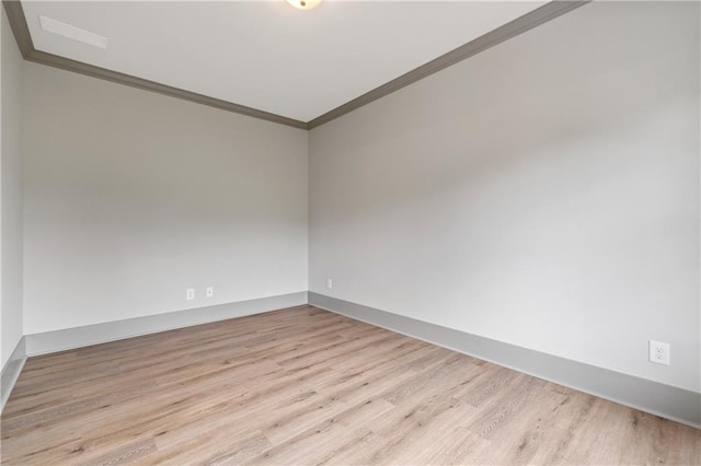 unfurnished room featuring crown molding and light wood-type flooring