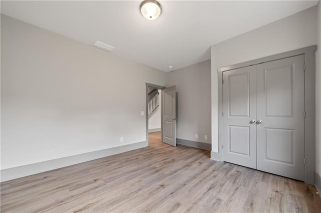 unfurnished bedroom featuring light hardwood / wood-style floors and a closet