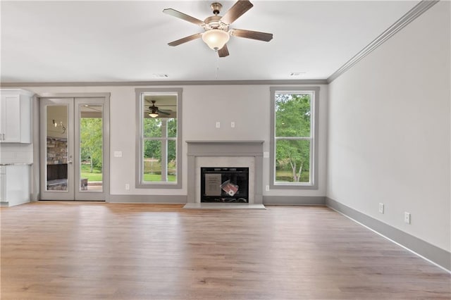 unfurnished living room with crown molding, plenty of natural light, and light hardwood / wood-style flooring