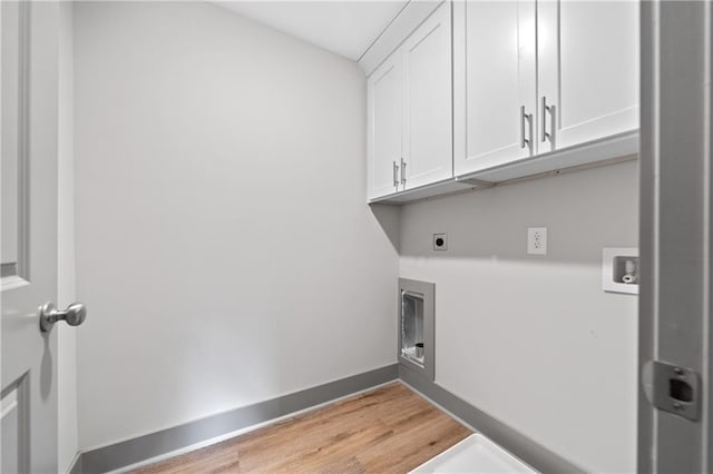 clothes washing area featuring cabinets, washer hookup, hookup for an electric dryer, and light wood-type flooring