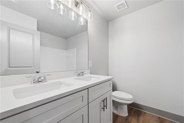 bathroom with vanity, wood-type flooring, and toilet