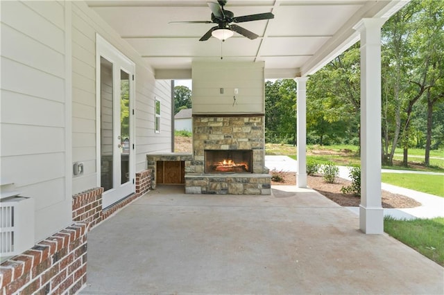 view of patio with ceiling fan and an outdoor stone fireplace