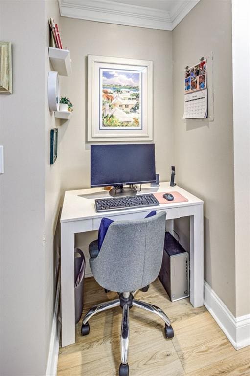 office space featuring light wood-style floors, baseboards, and crown molding