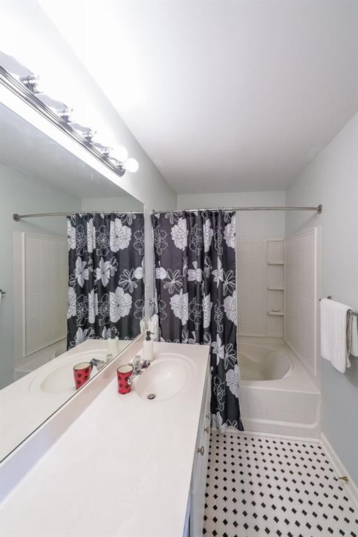 bathroom featuring baseboards, shower / bath combo, and vanity