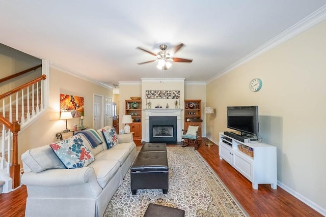 living area featuring ornamental molding, wood finished floors, and stairway