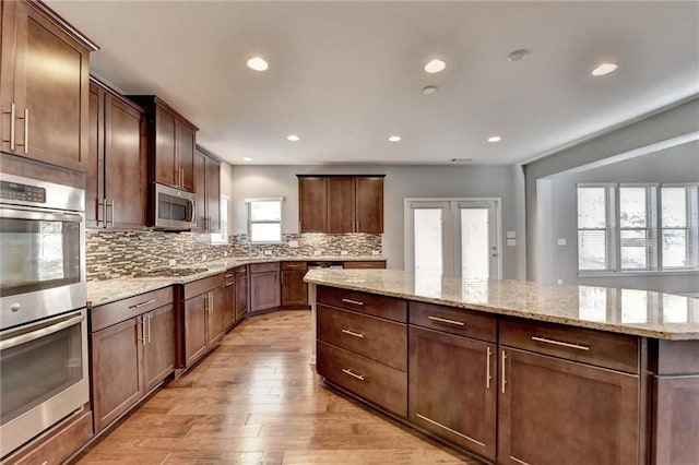 kitchen with tasteful backsplash, stainless steel appliances, and a healthy amount of sunlight