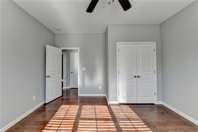 unfurnished bedroom with ceiling fan, dark hardwood / wood-style floors, and a closet