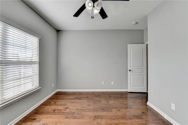 spare room with wood-type flooring, a healthy amount of sunlight, and ceiling fan