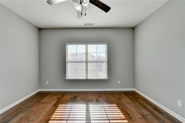 spare room featuring ceiling fan and dark wood-type flooring