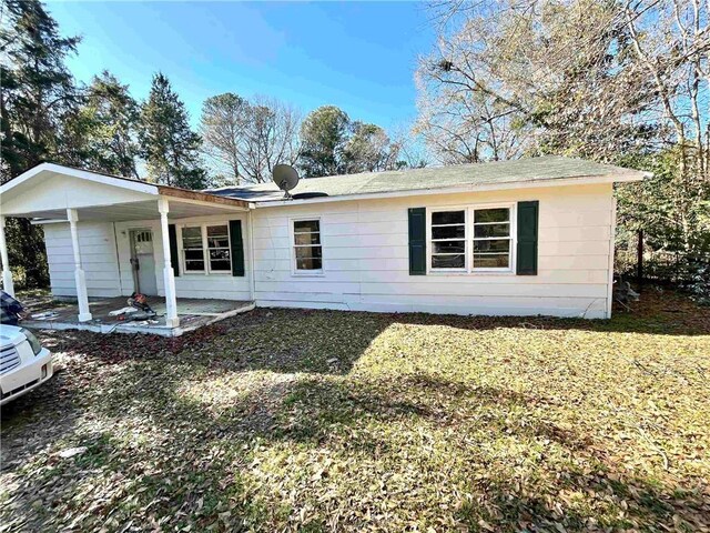 rear view of house featuring a yard