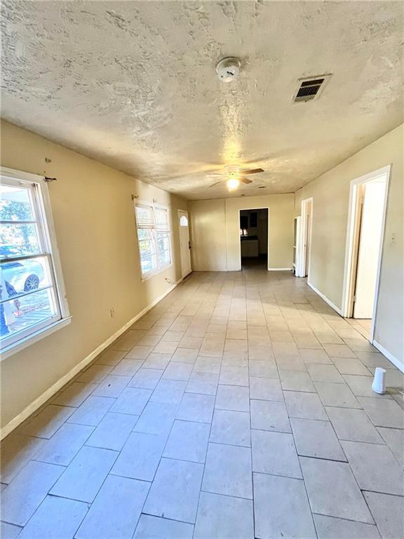 unfurnished living room featuring ceiling fan