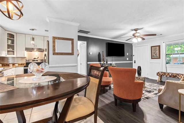 dining room with crown molding, ceiling fan, wood finished floors, and visible vents