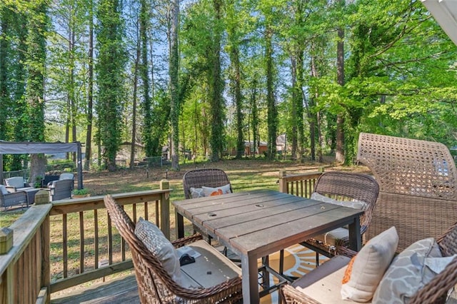 wooden terrace featuring outdoor dining space and a fenced backyard