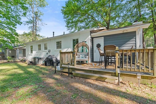 back of property with a wooden deck and a yard