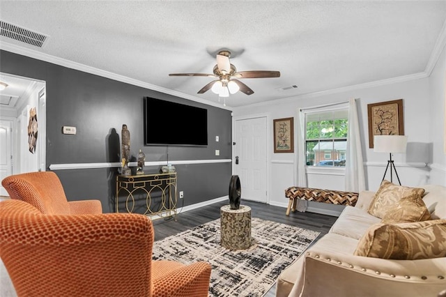 living area with wood finished floors, visible vents, and crown molding