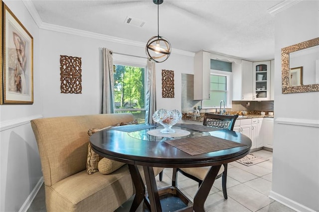 dining room with crown molding, light tile patterned flooring, visible vents, and baseboards