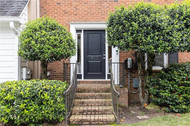 doorway to property with brick siding
