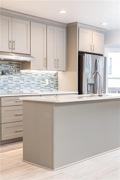 kitchen featuring gray cabinetry, stainless steel fridge with ice dispenser, and light countertops