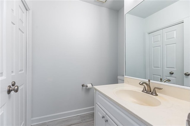 bathroom with vanity, baseboards, and wood finished floors