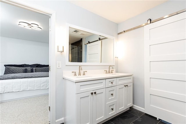 ensuite bathroom featuring double vanity, visible vents, a sink, and connected bathroom