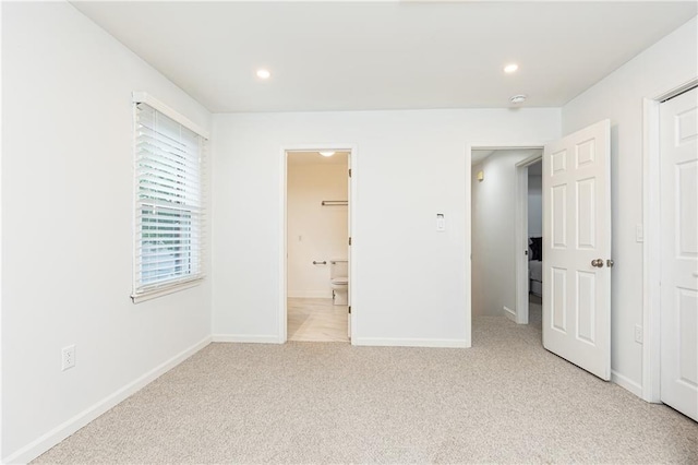 unfurnished bedroom featuring baseboards, light carpet, recessed lighting, and connected bathroom