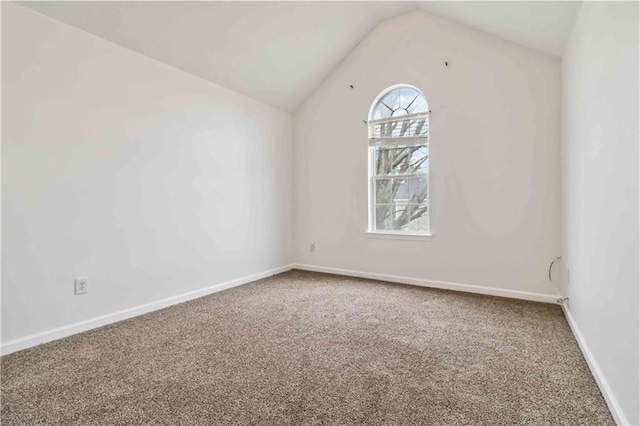 empty room featuring vaulted ceiling and carpet