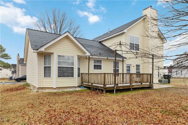 rear view of house featuring a wooden deck, a yard, and cooling unit