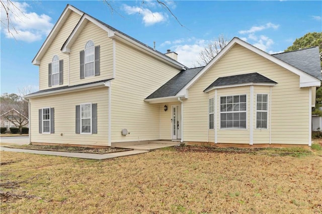 rear view of property featuring a lawn and a patio