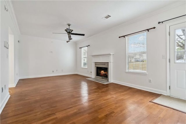 unfurnished living room with crown molding, ceiling fan, and dark hardwood / wood-style floors