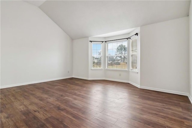 empty room with vaulted ceiling and dark hardwood / wood-style floors