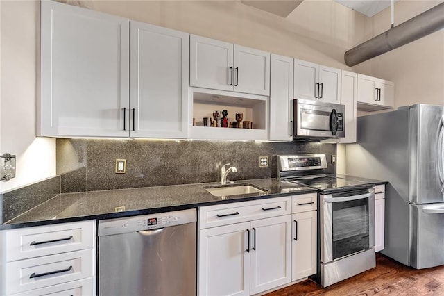 kitchen featuring dark stone counters, white cabinets, sink, dark hardwood / wood-style floors, and appliances with stainless steel finishes