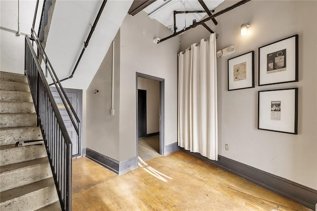 stairs with a towering ceiling and concrete floors