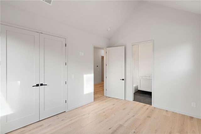 unfurnished bedroom with lofted ceiling and light wood-type flooring