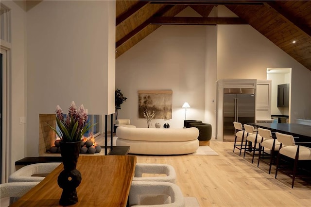 living room with beam ceiling, light hardwood / wood-style floors, high vaulted ceiling, and wood ceiling