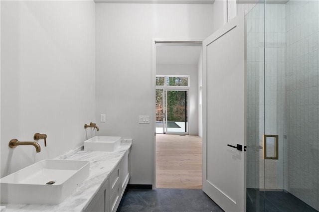 bathroom featuring vanity and a shower with door