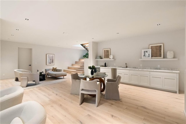 living room with light hardwood / wood-style flooring and sink