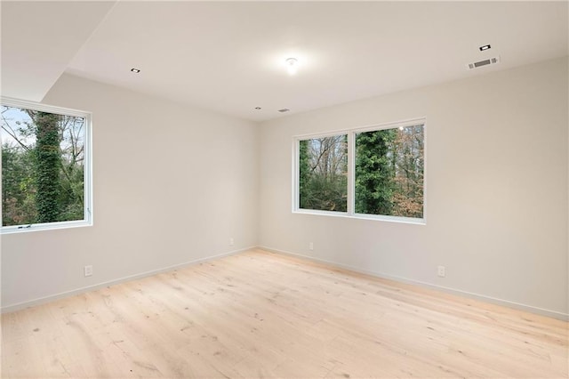 unfurnished room featuring light hardwood / wood-style floors and a wealth of natural light