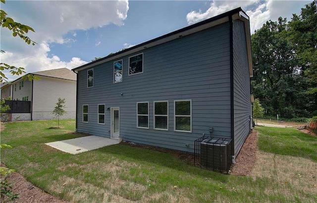 back of house featuring a patio, a lawn, and central AC